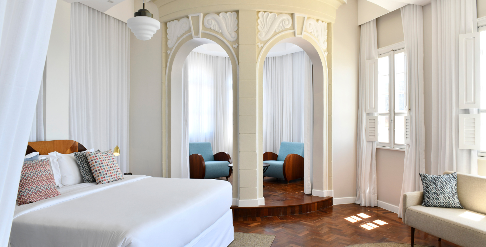 a room with a bed and chairs