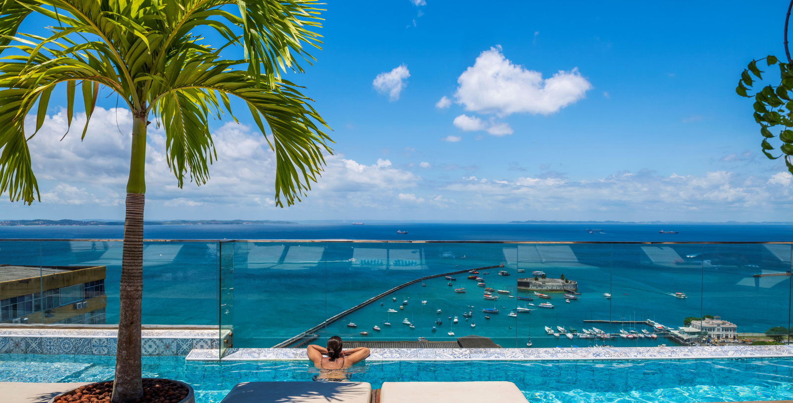 a woman in a pool overlooking a body of water