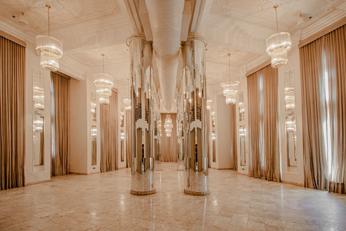 a large room with multiple columns and chandeliers