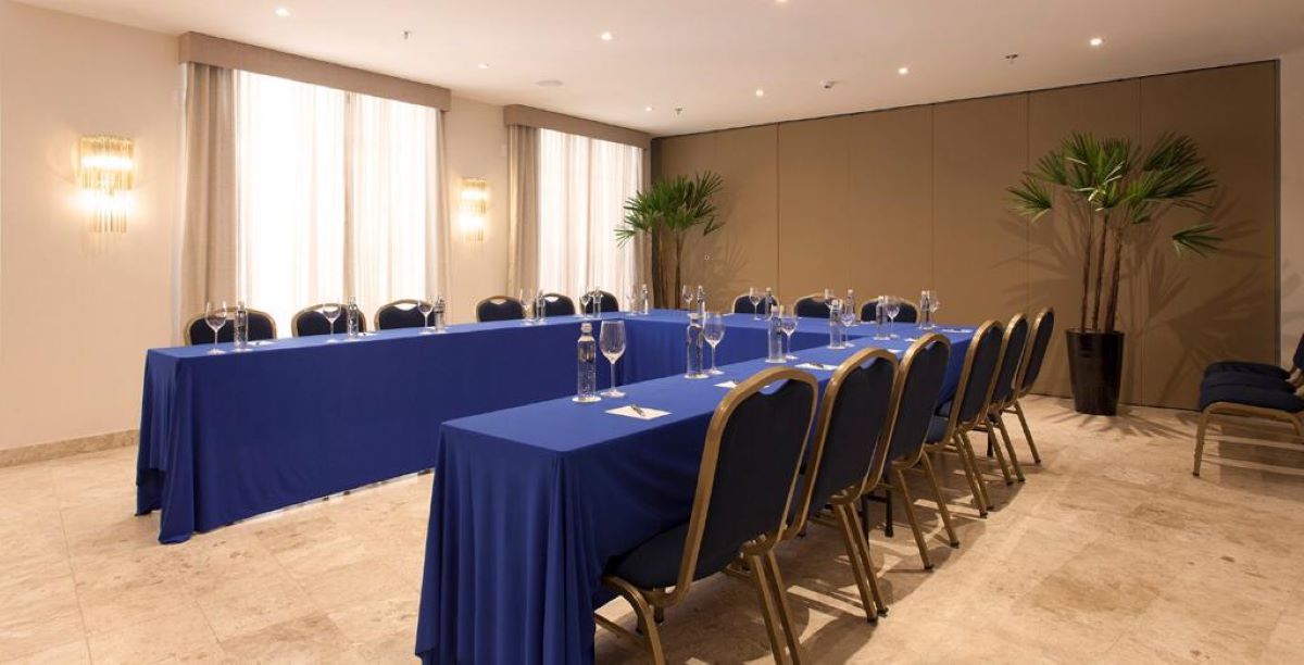 a long table with blue tablecloths and glasses