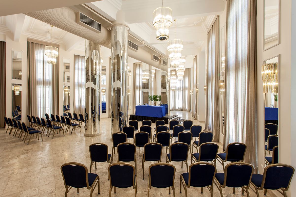 a room with many chairs and chandeliers