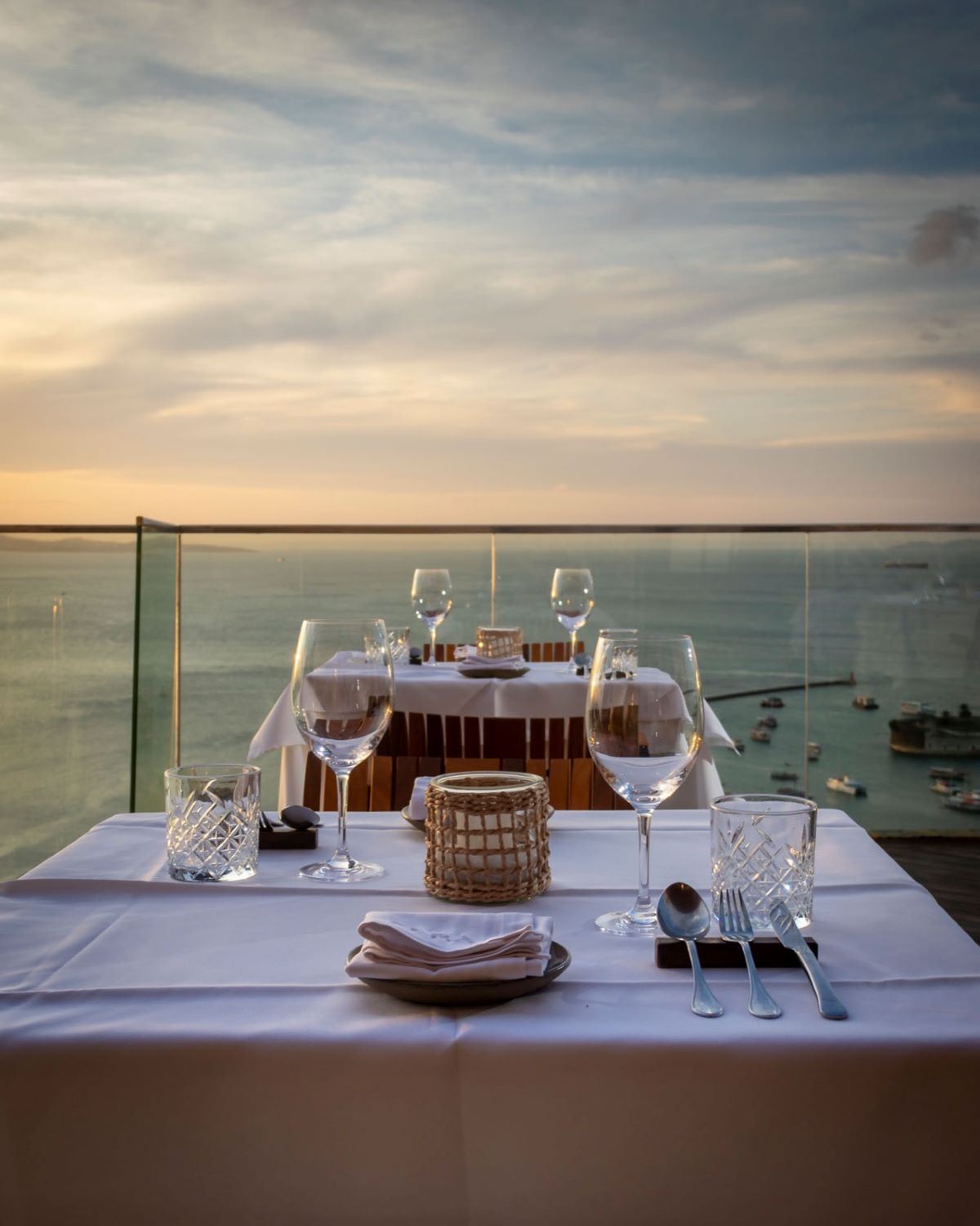 a table set for a dinner with a view of the ocean