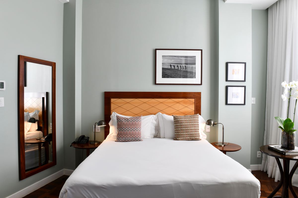 a bed with white sheets and pillows in a room