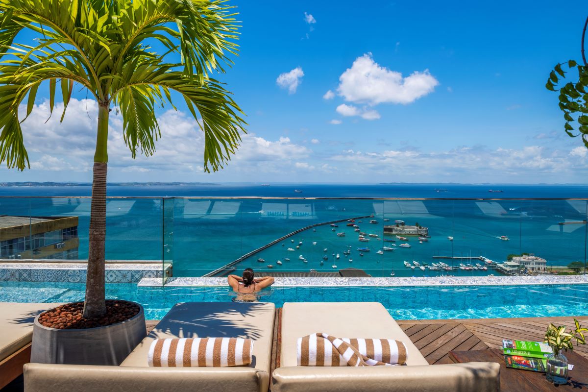 a person in a pool with a palm tree and a palm tree
