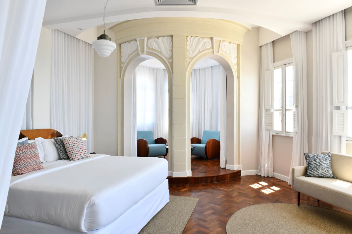 a room with a bed and chairs