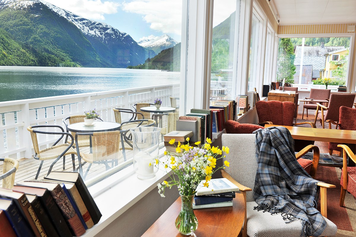 a room with a window and a view of the mountains and water