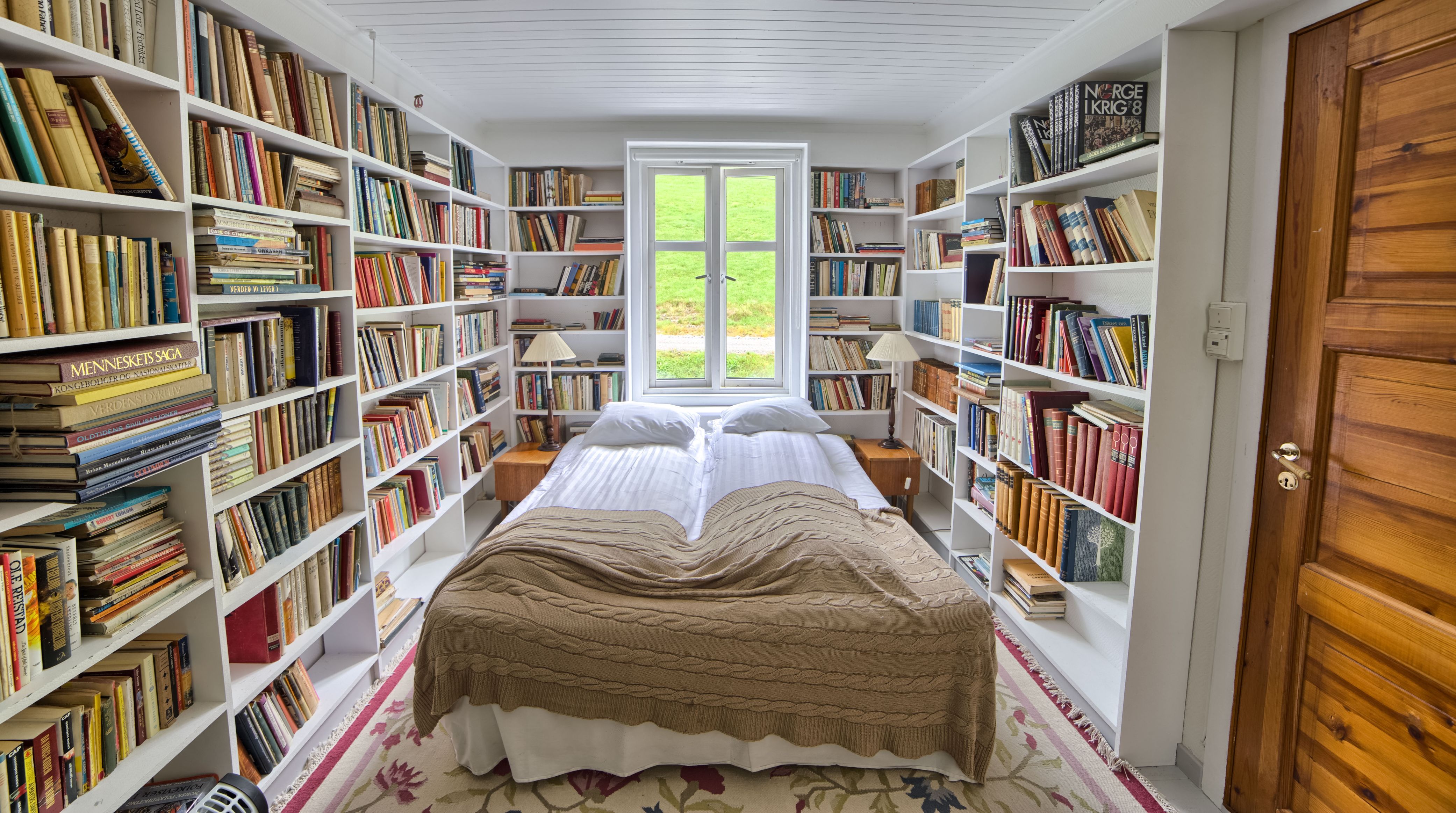 a room with a bed and bookshelves