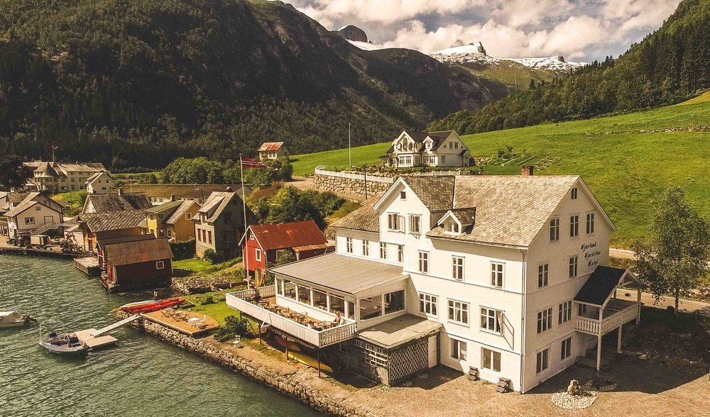 a white house next to a body of water