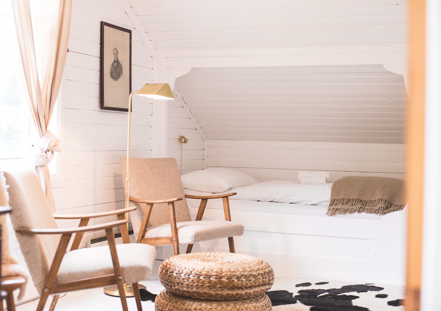 a room with a bed and chairs