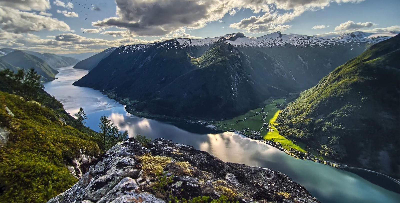 a river and mountains with snow on the side
