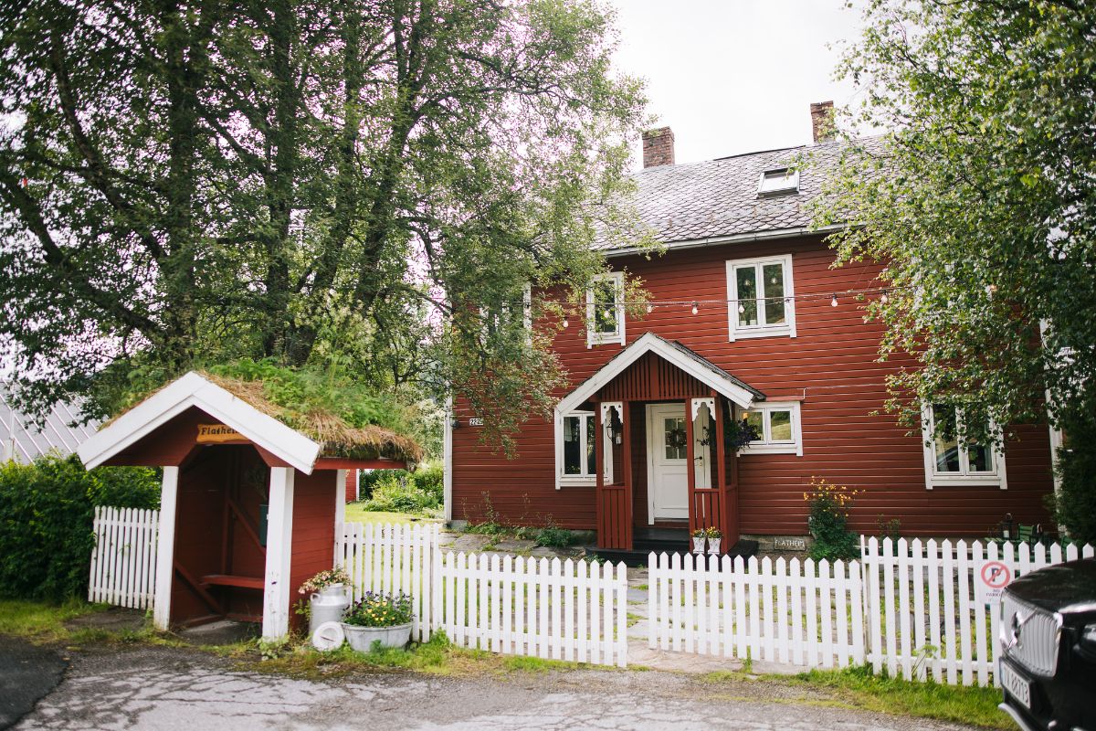 a house with a white fence and trees