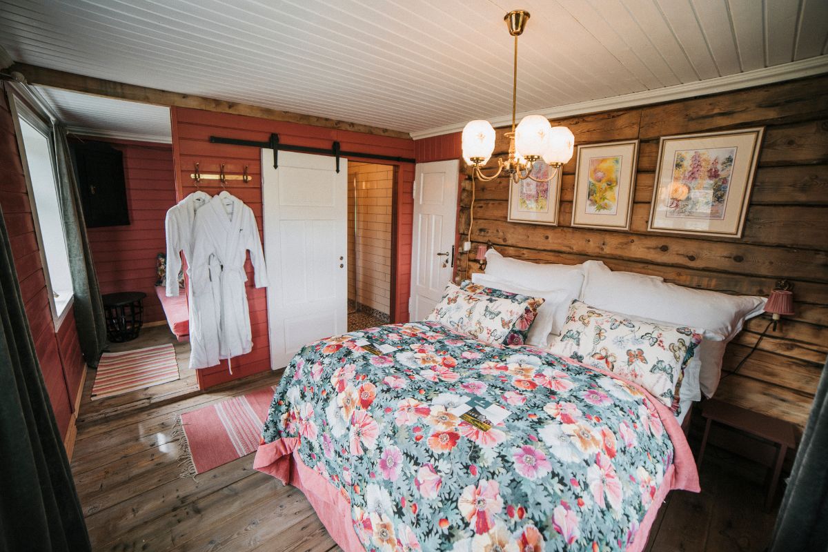 a bed with a floral bedding and a wood wall