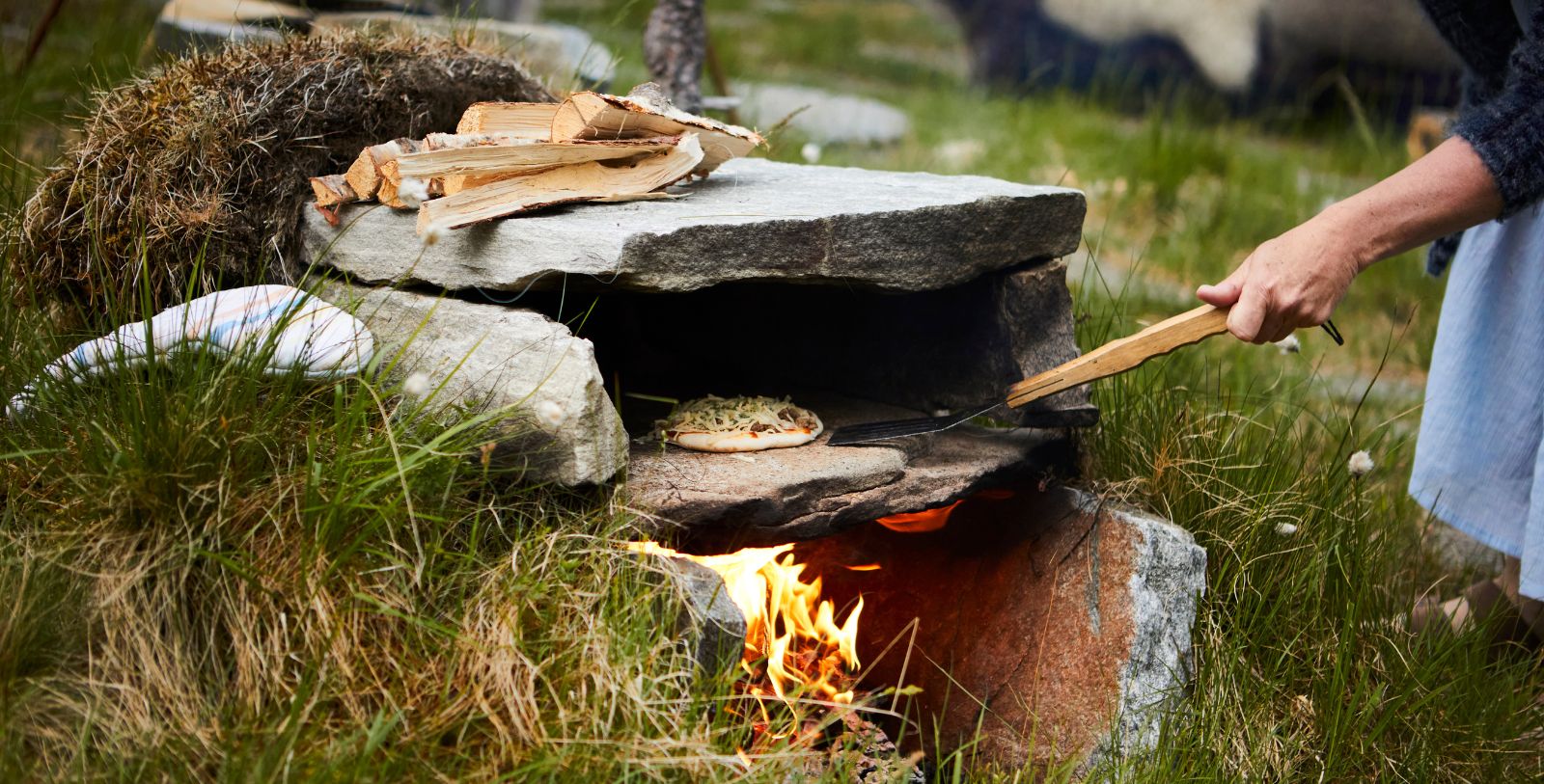 a stone oven with a fire and a pizza on it