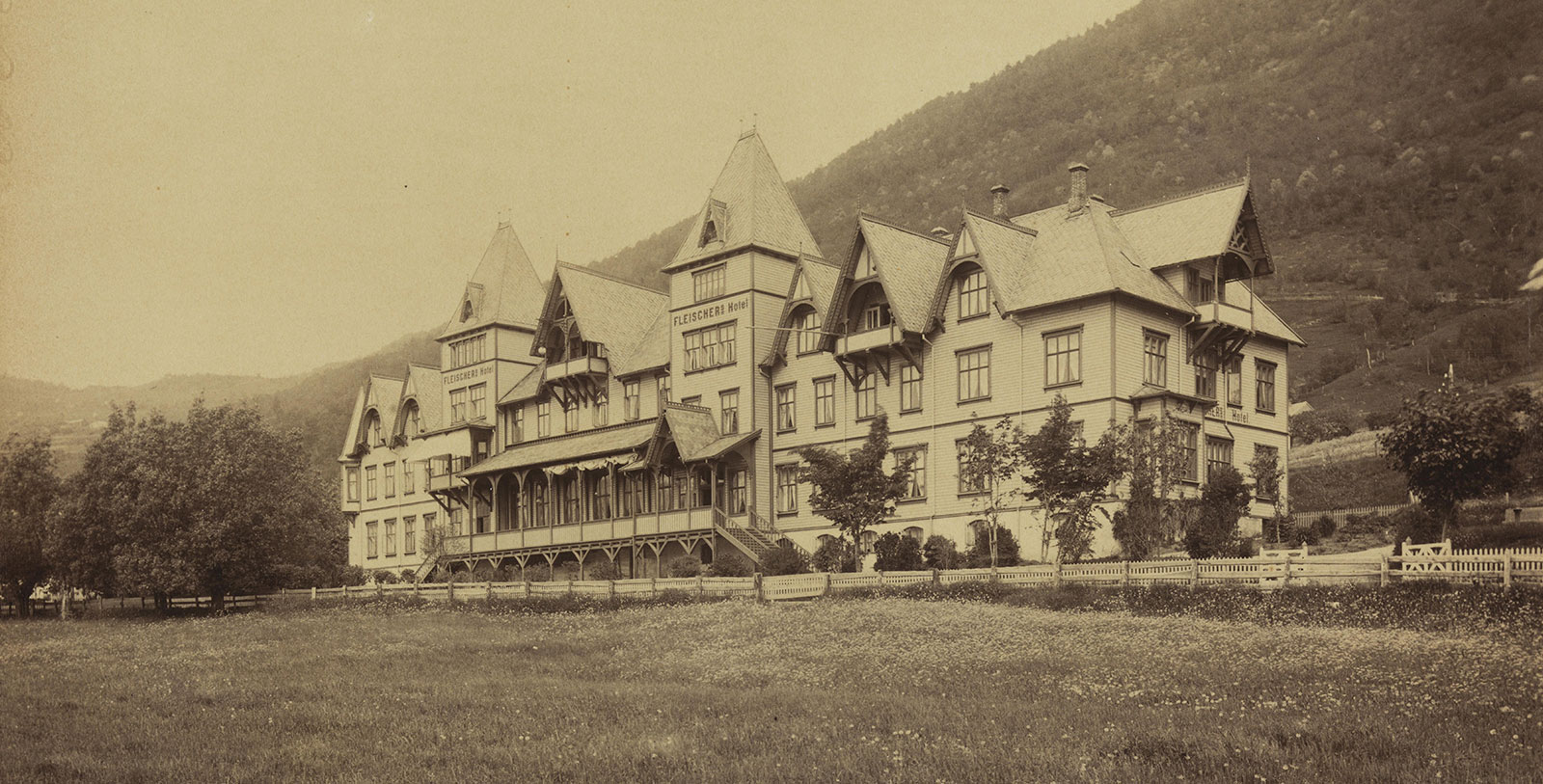 a large building with a lawn and trees