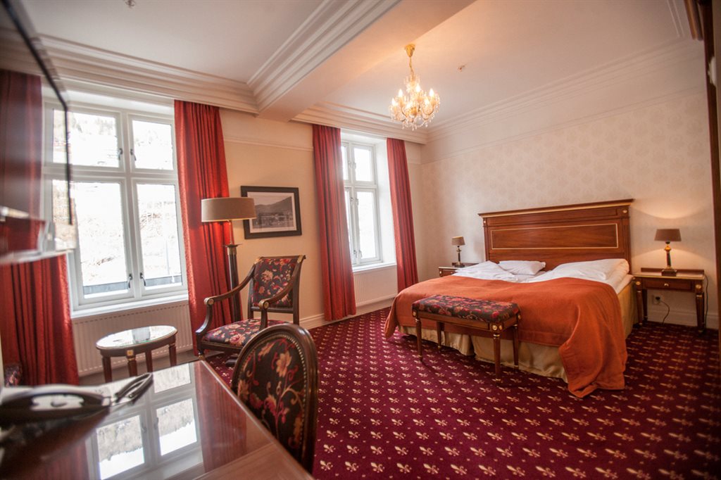 a room with a bed and chairs