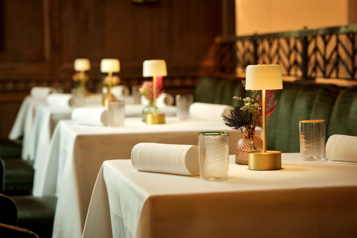 a table with white tablecloths and lamps