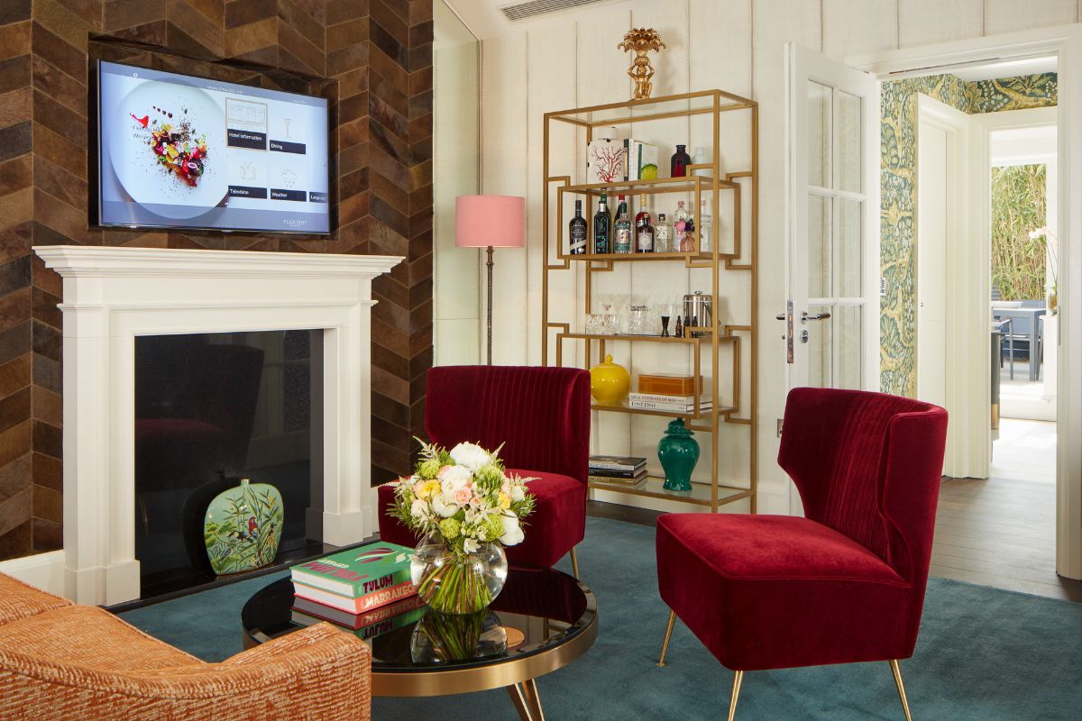a living room with red chairs and a fireplace