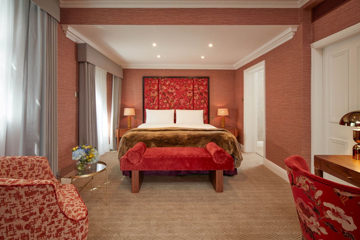 a bedroom with a bed and a red wall