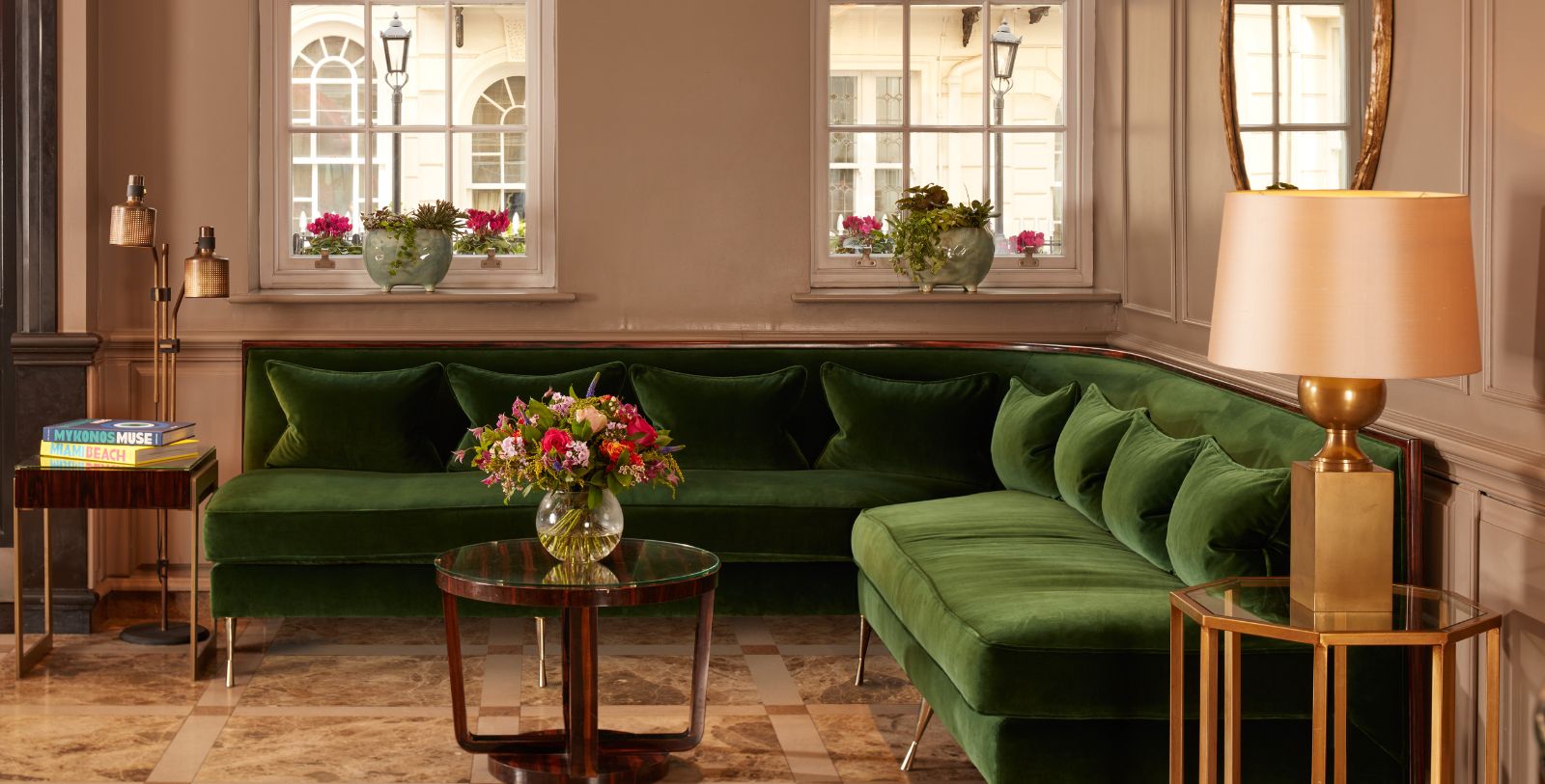 a green couch with flowers in a vase