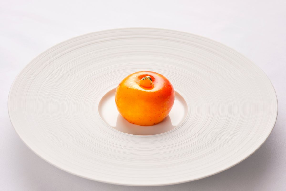 a round orange object on a white plate