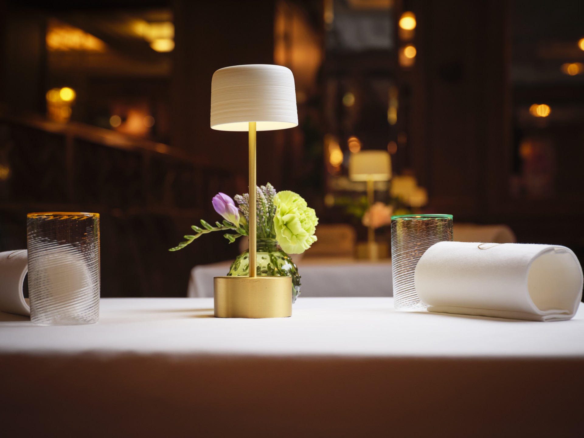 a table with a lamp and flowers on it