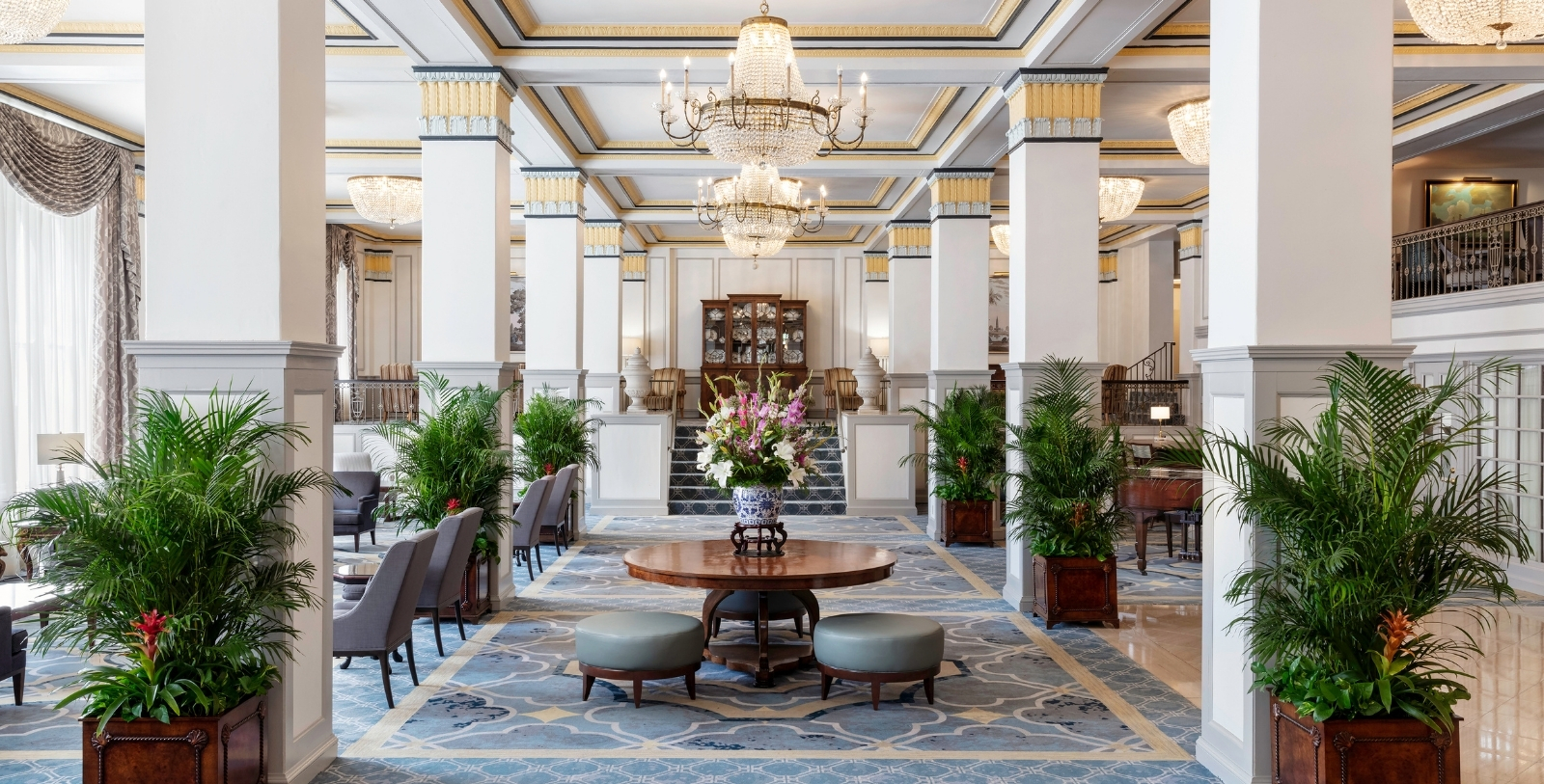 a room with a chandelier and a table with flowers