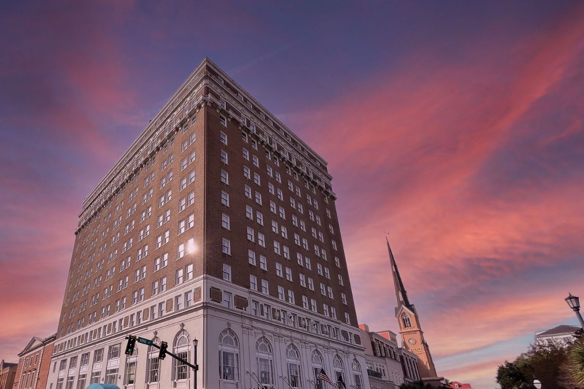 a building with a steeple and a pink sky