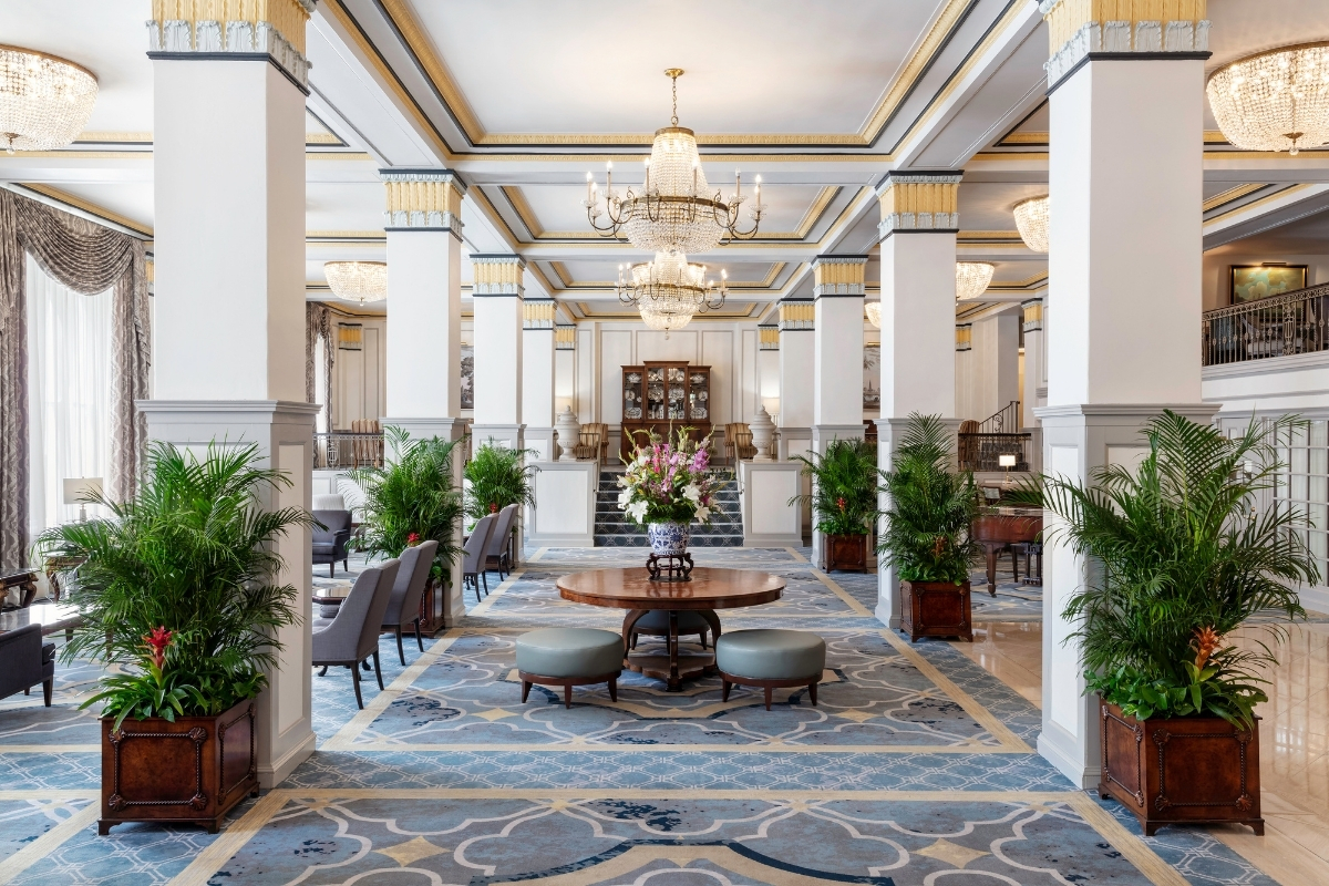 a room with a chandelier and a table with flowers