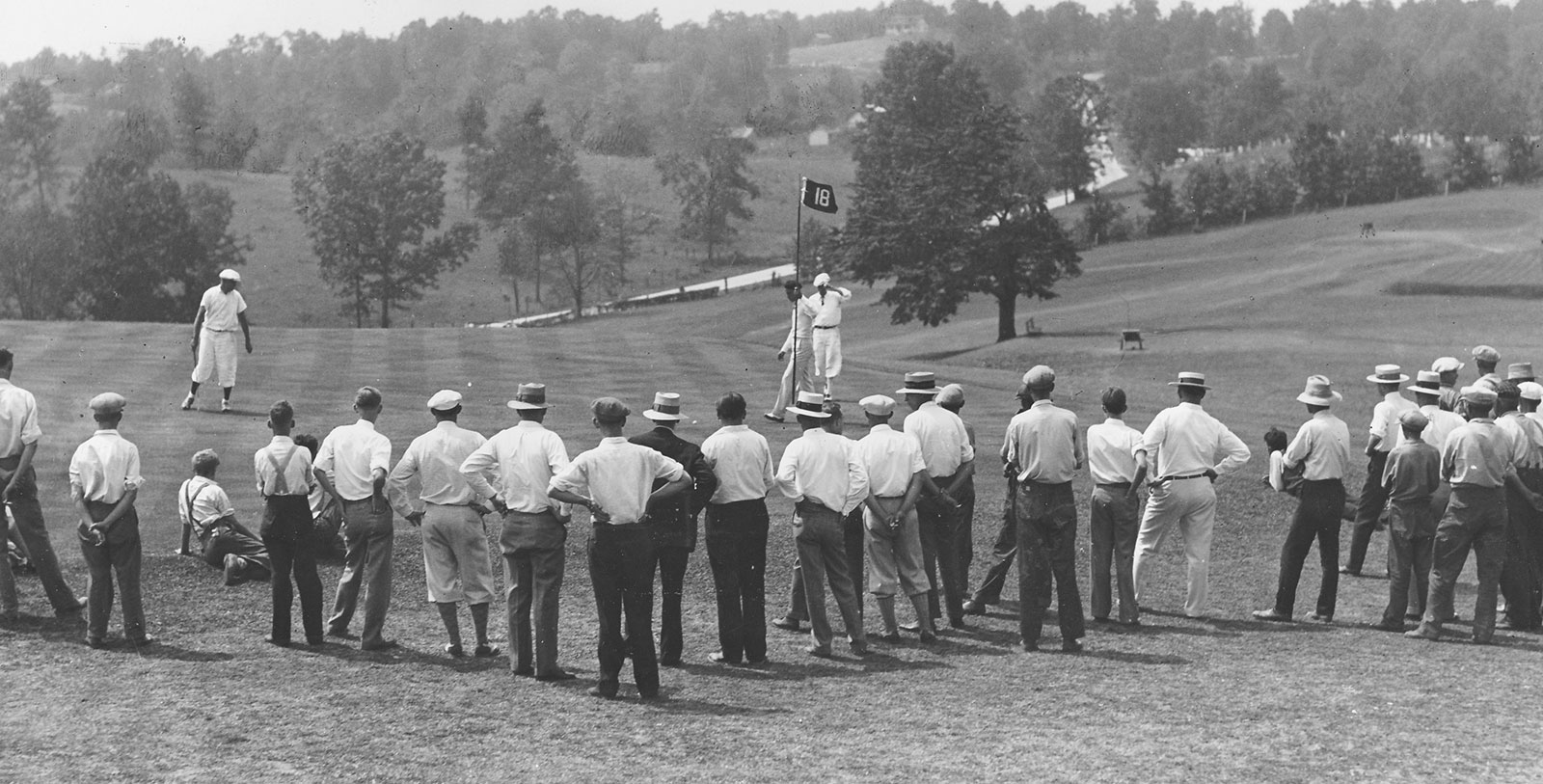 a group of men standing on a golf course