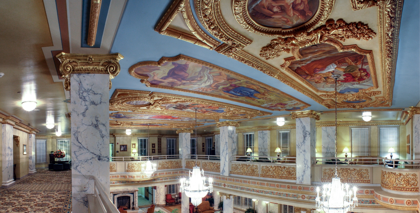 a large ornate building with a chandelier and paintings