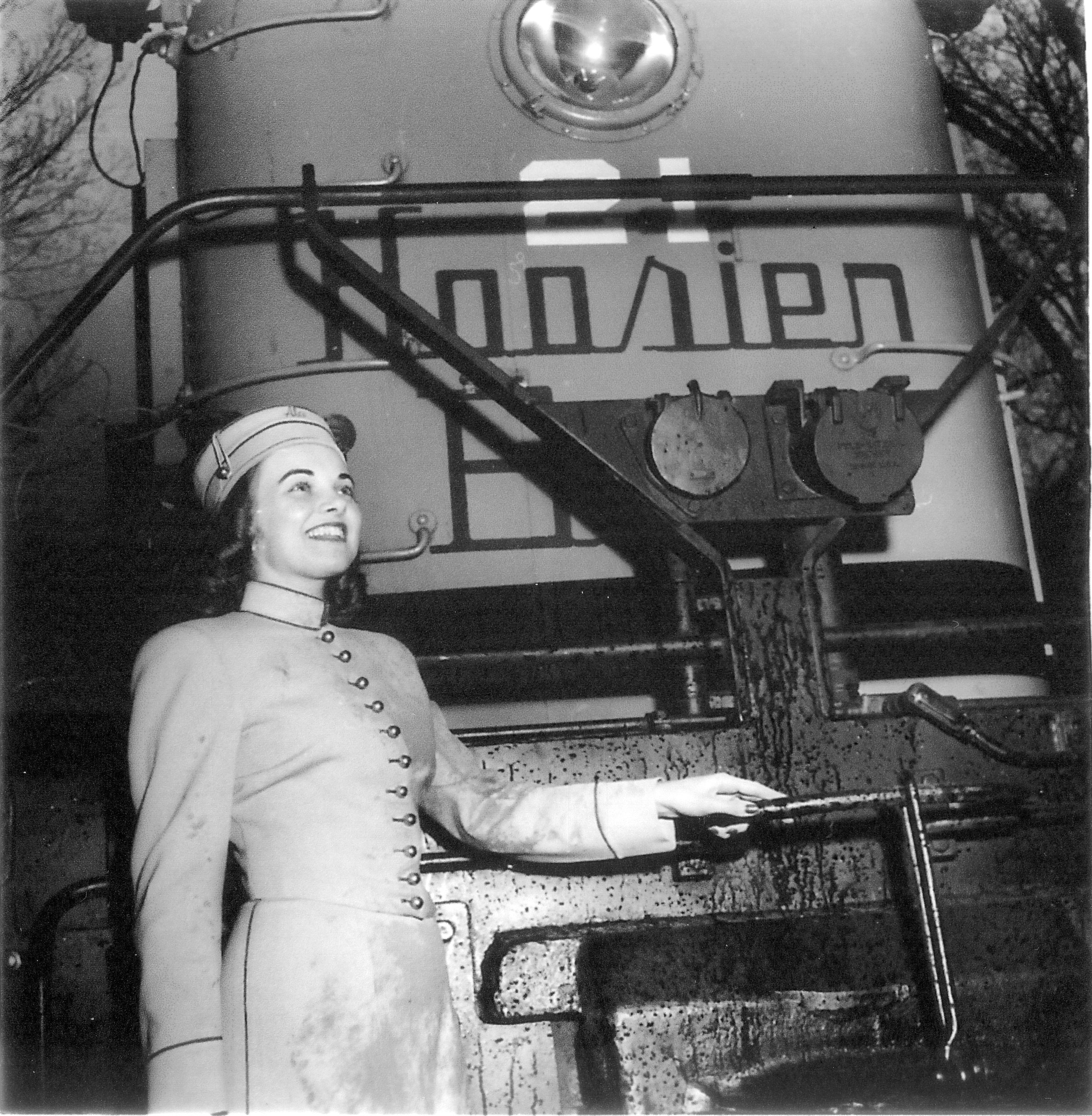 a woman in uniform standing next to a train
