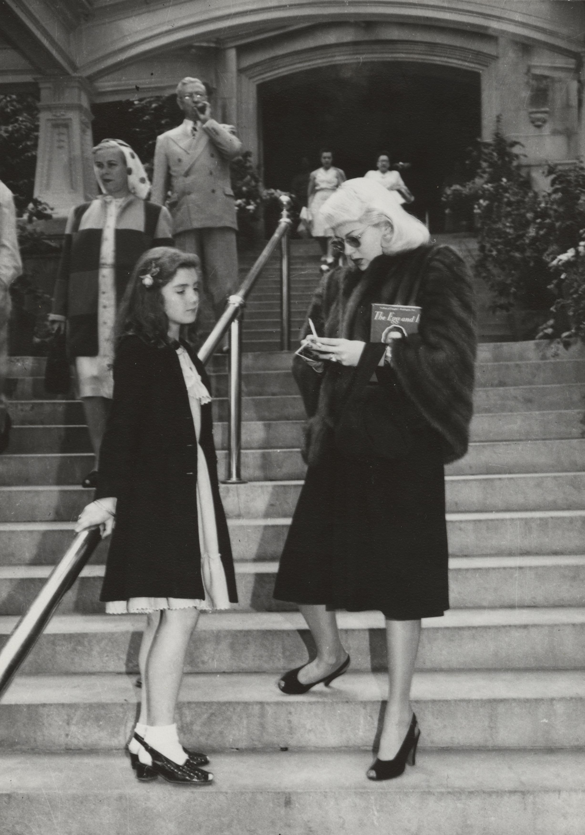 a woman looking at a girl on a staircase