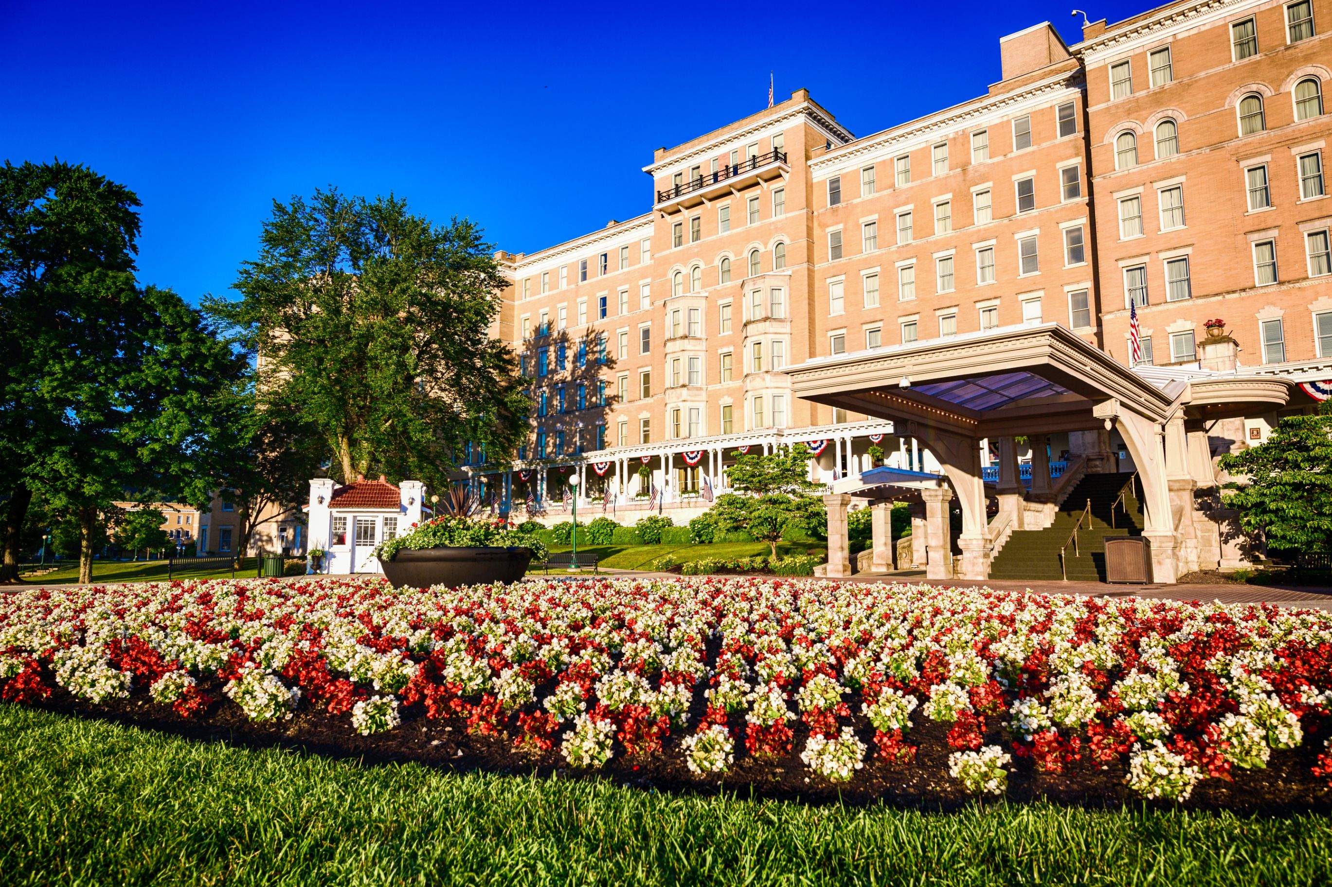 a large building with a lawn and flowers