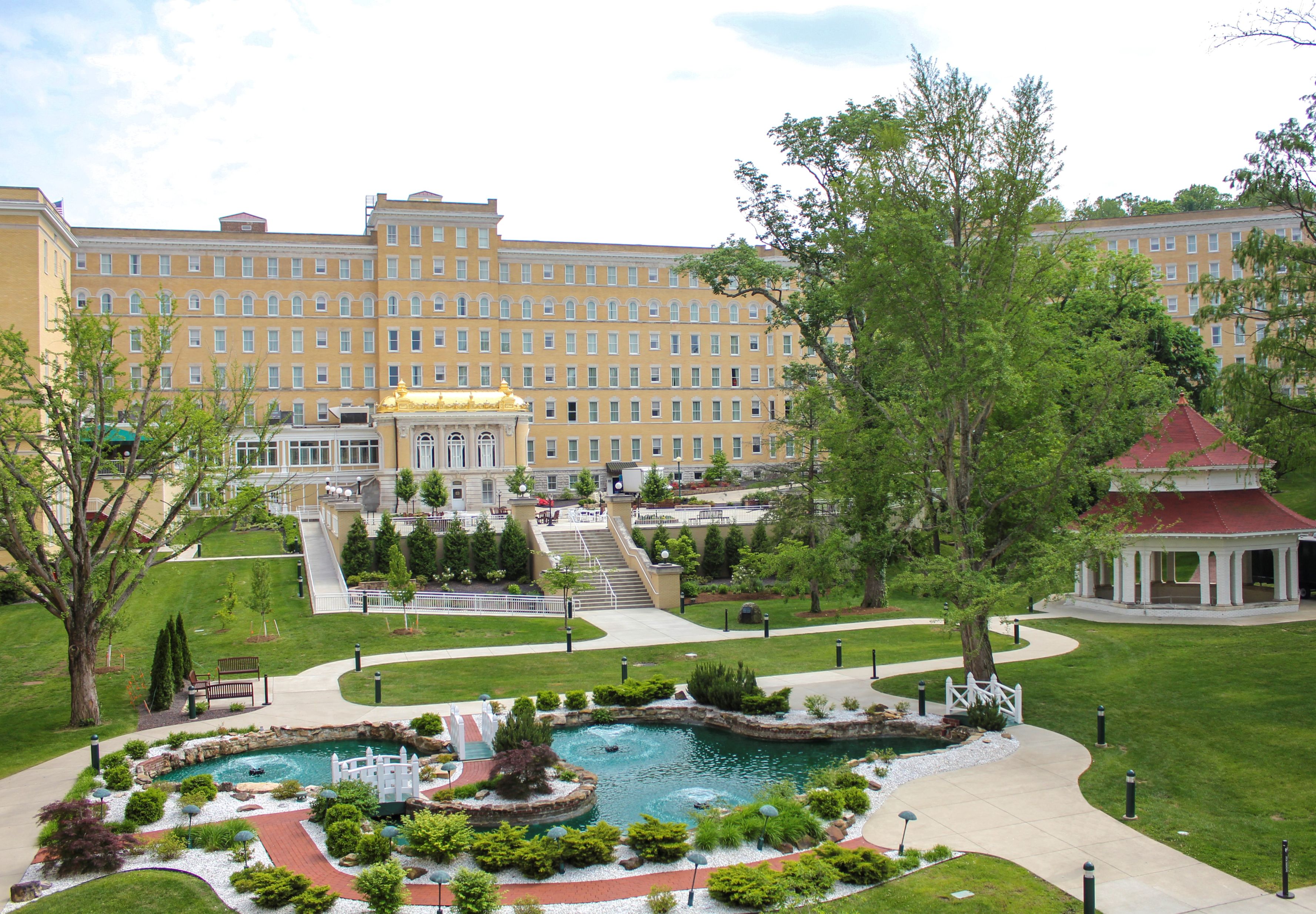 a large building with a fountain and trees