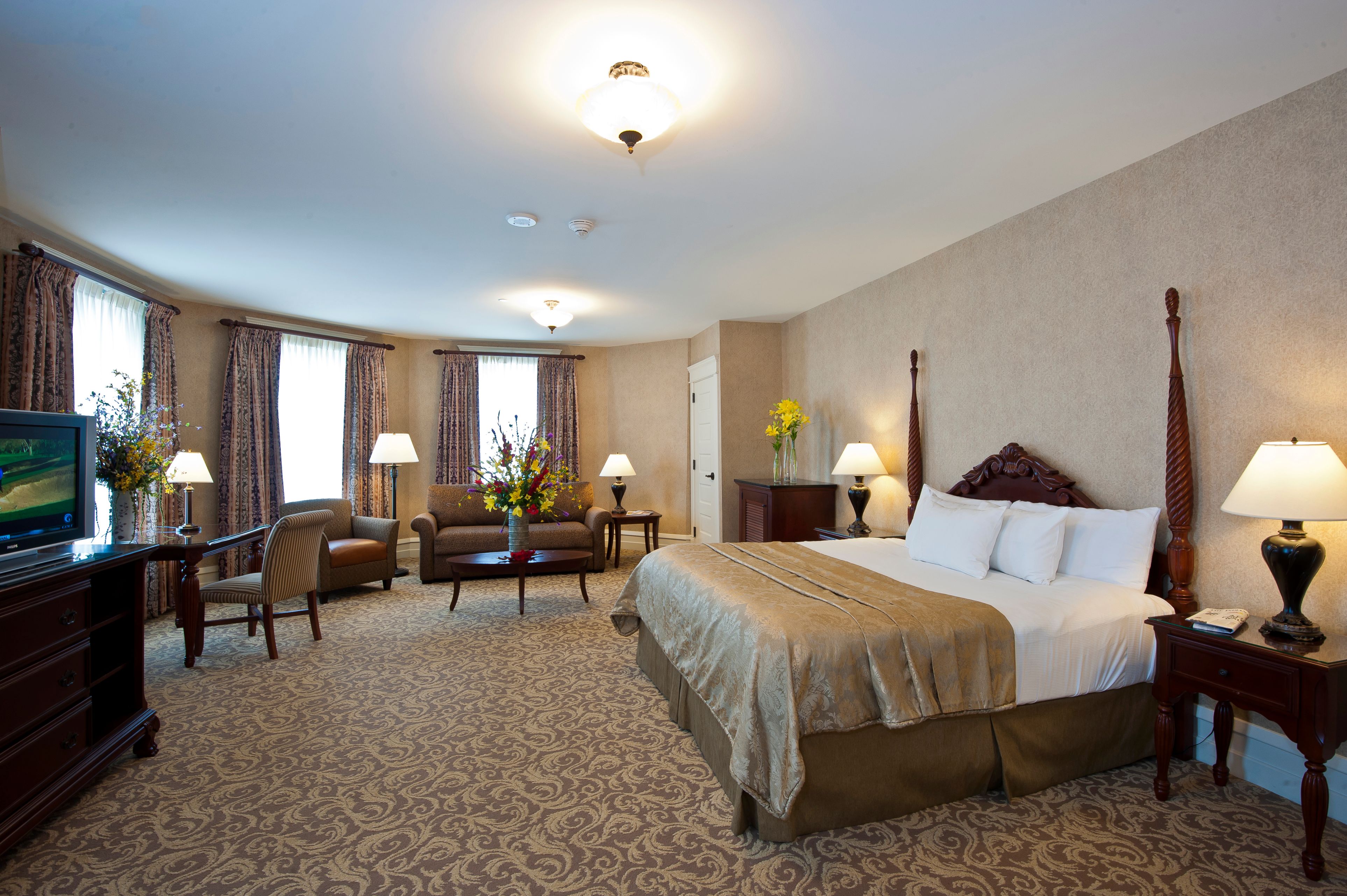 a room with a bed and chairs
