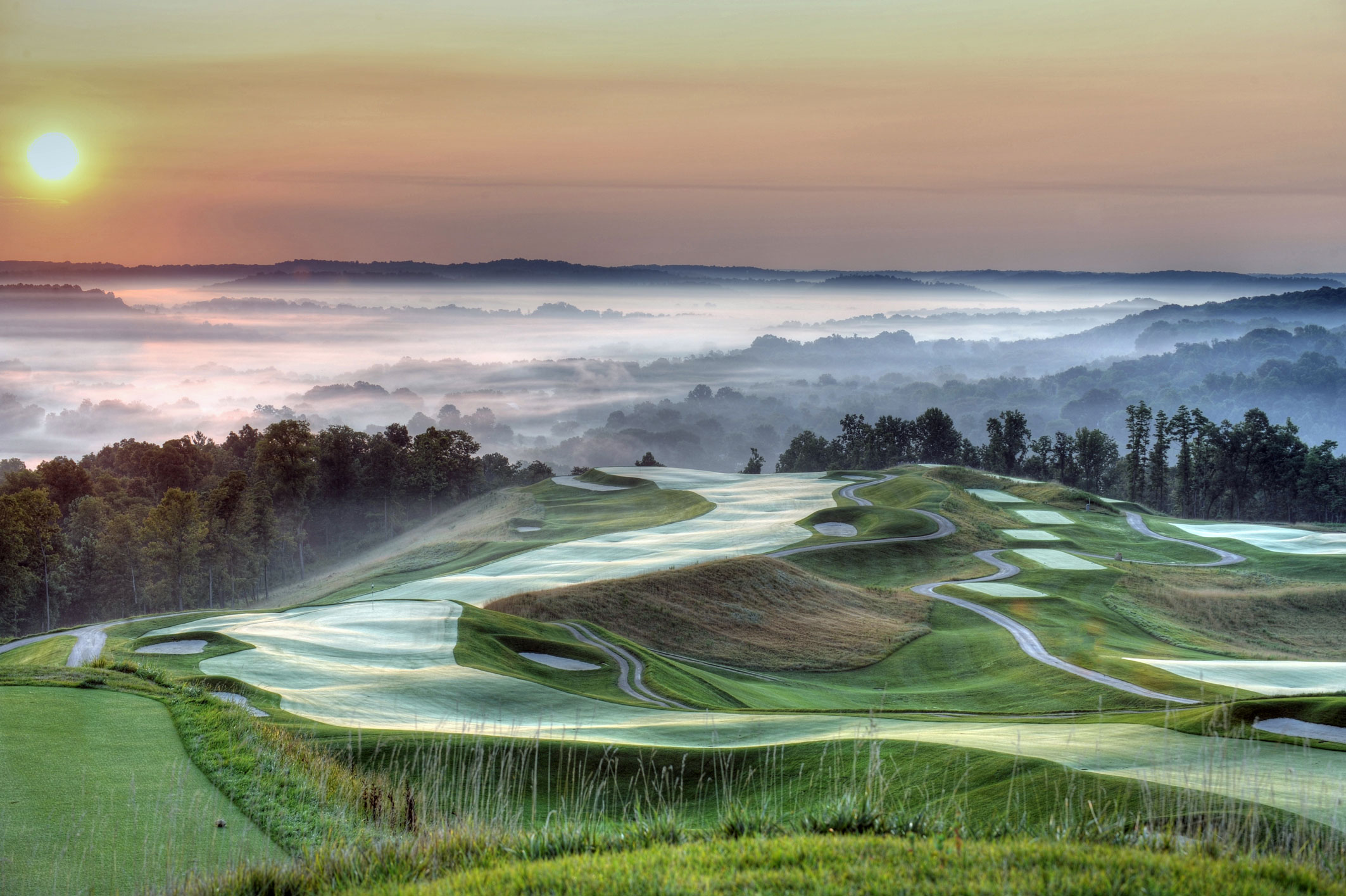 a golf course with a foggy landscape