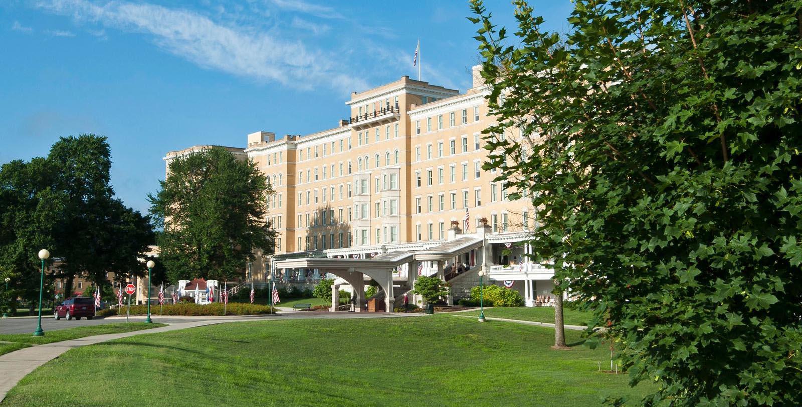 a large building with a lawn and trees