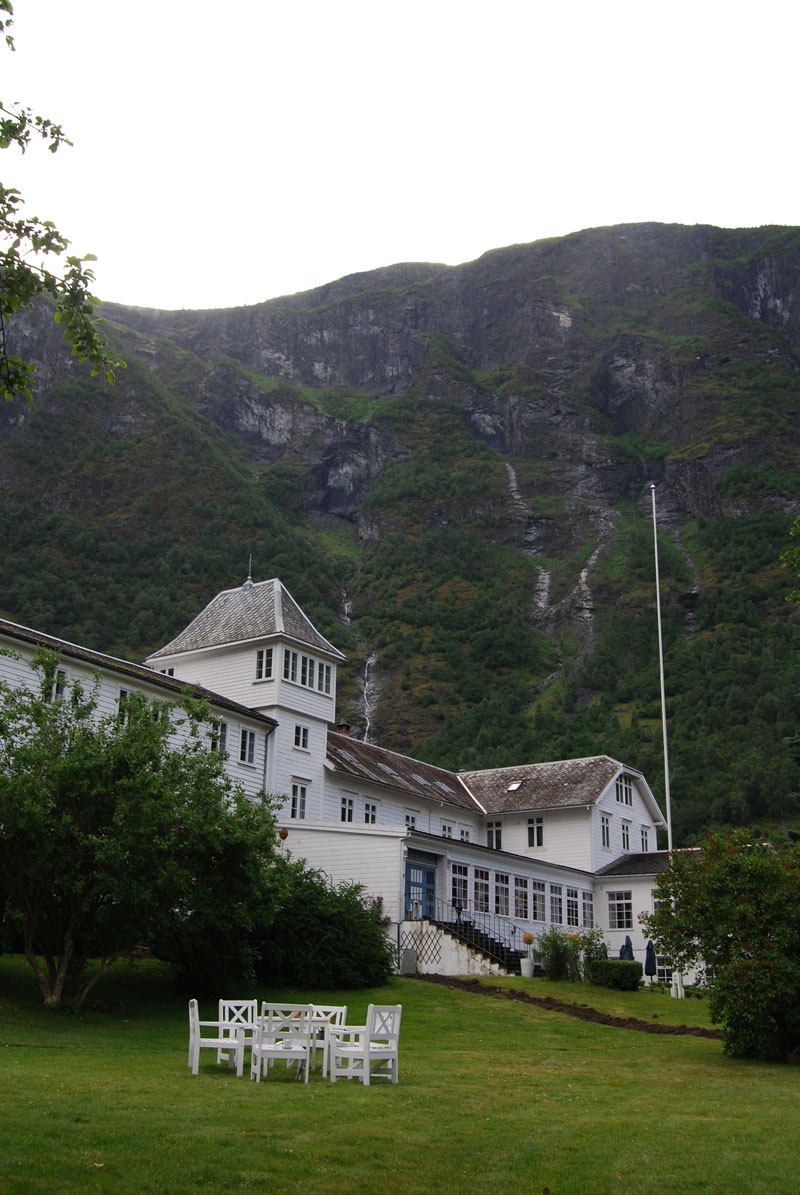 a large white building with a large mountain behind it