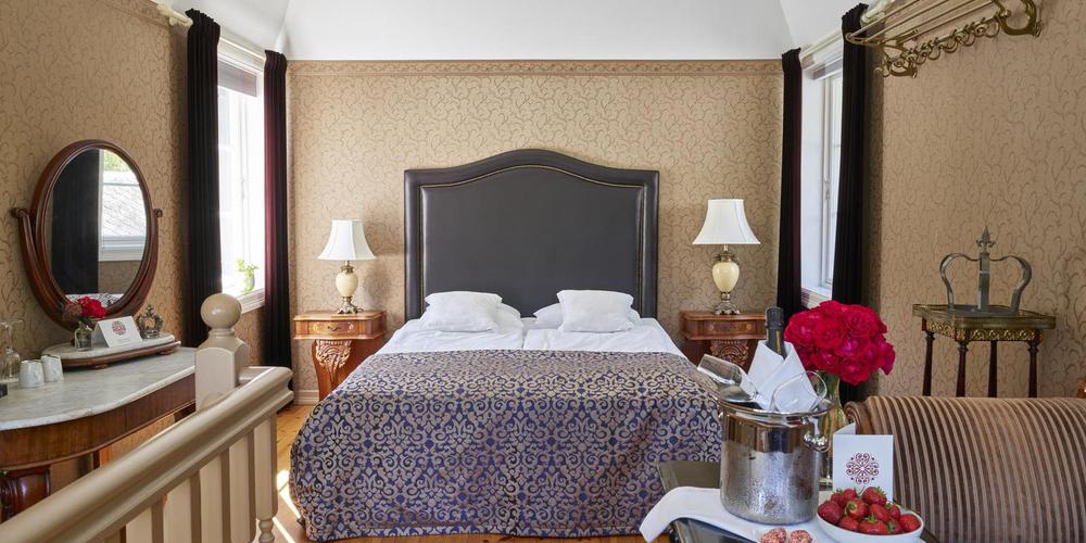 a bed with a headboard and lamps in a room