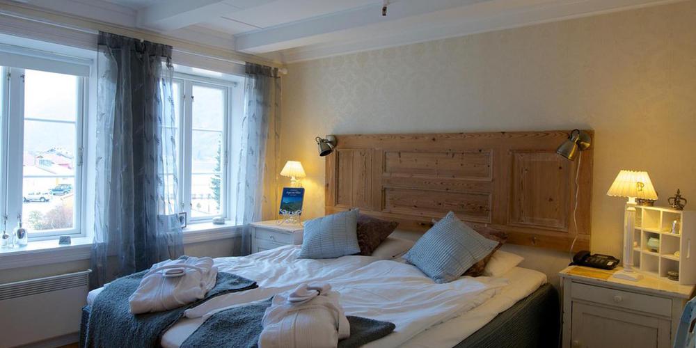 a bed with a wooden headboard and a lamp