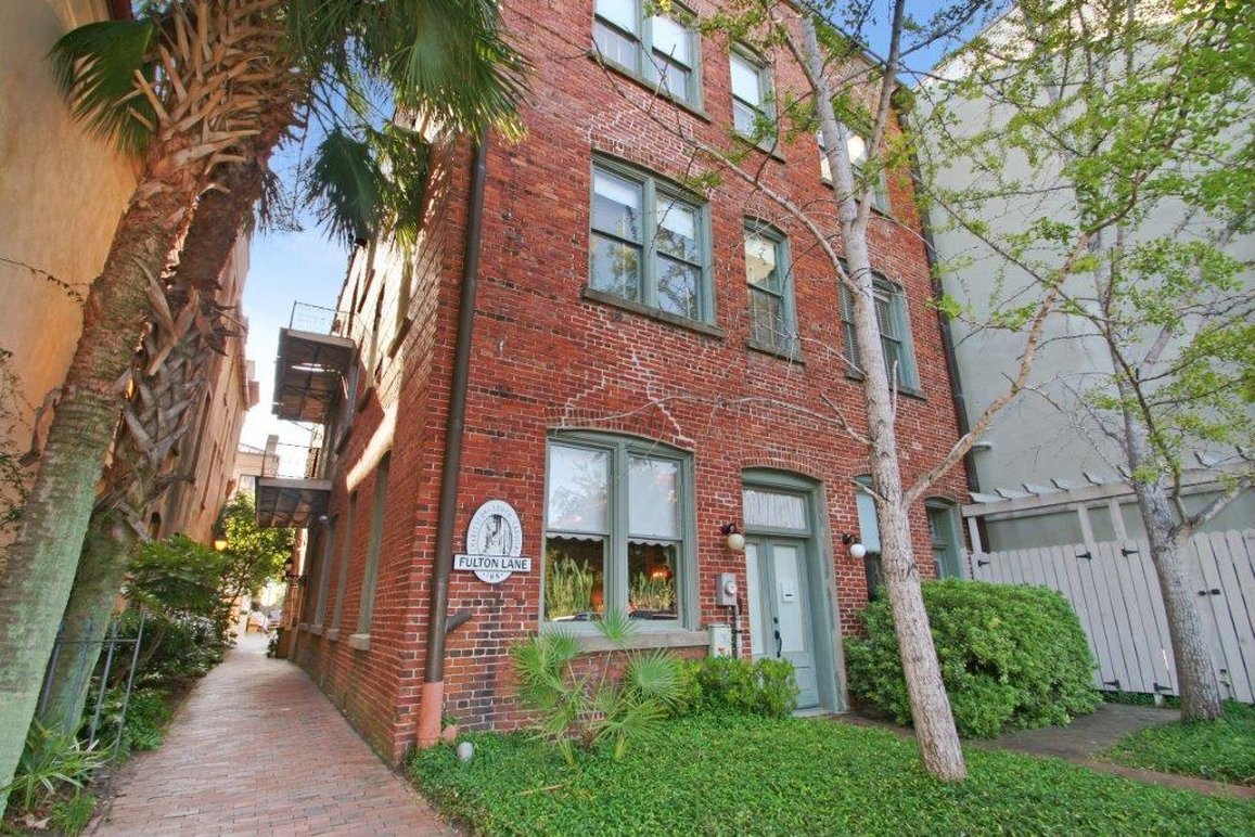 a brick building with trees and grass