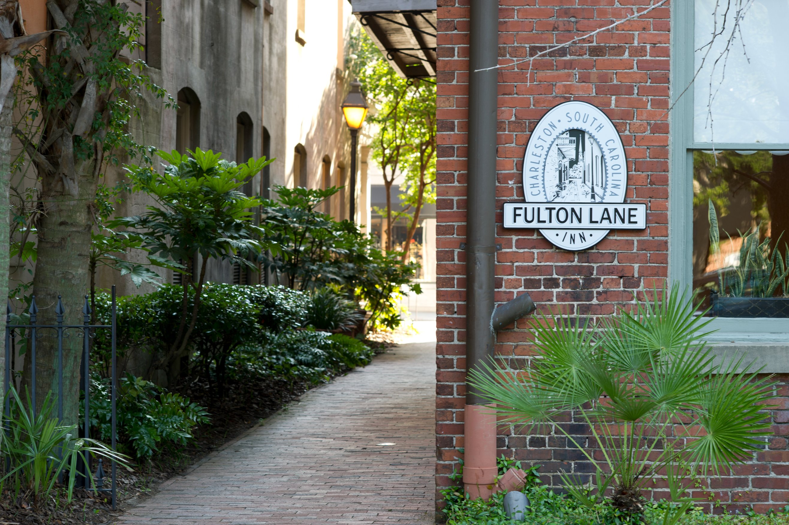 a brick walkway with a sign on the side