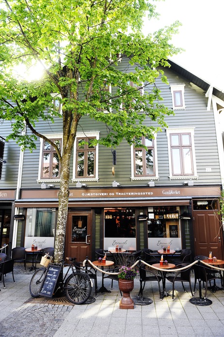 a tree with tables and chairs outside of a restaurant