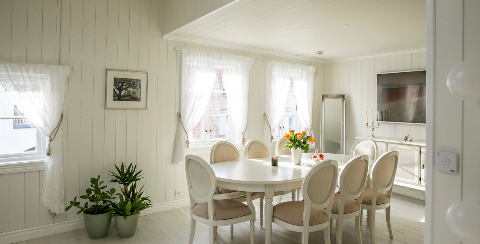 a white dining room with a table and chairs