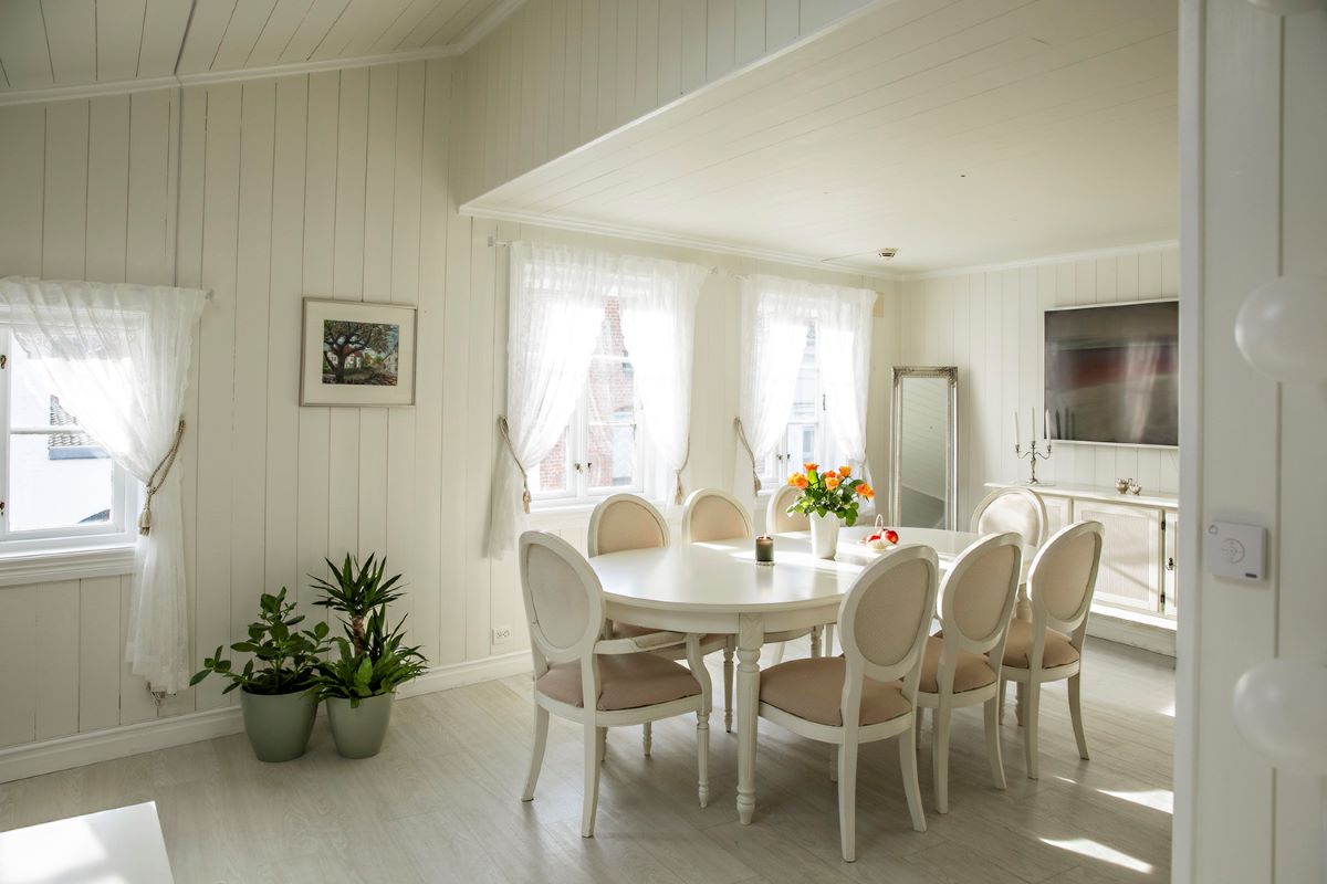 a white dining room with a table and chairs