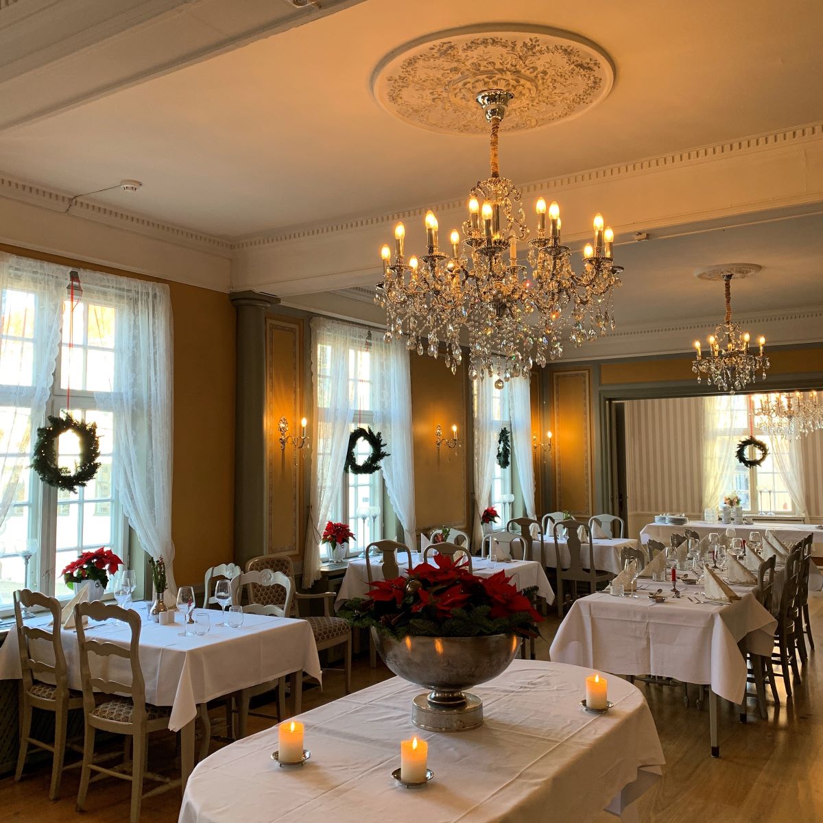 a room with tables and chairs and chandeliers