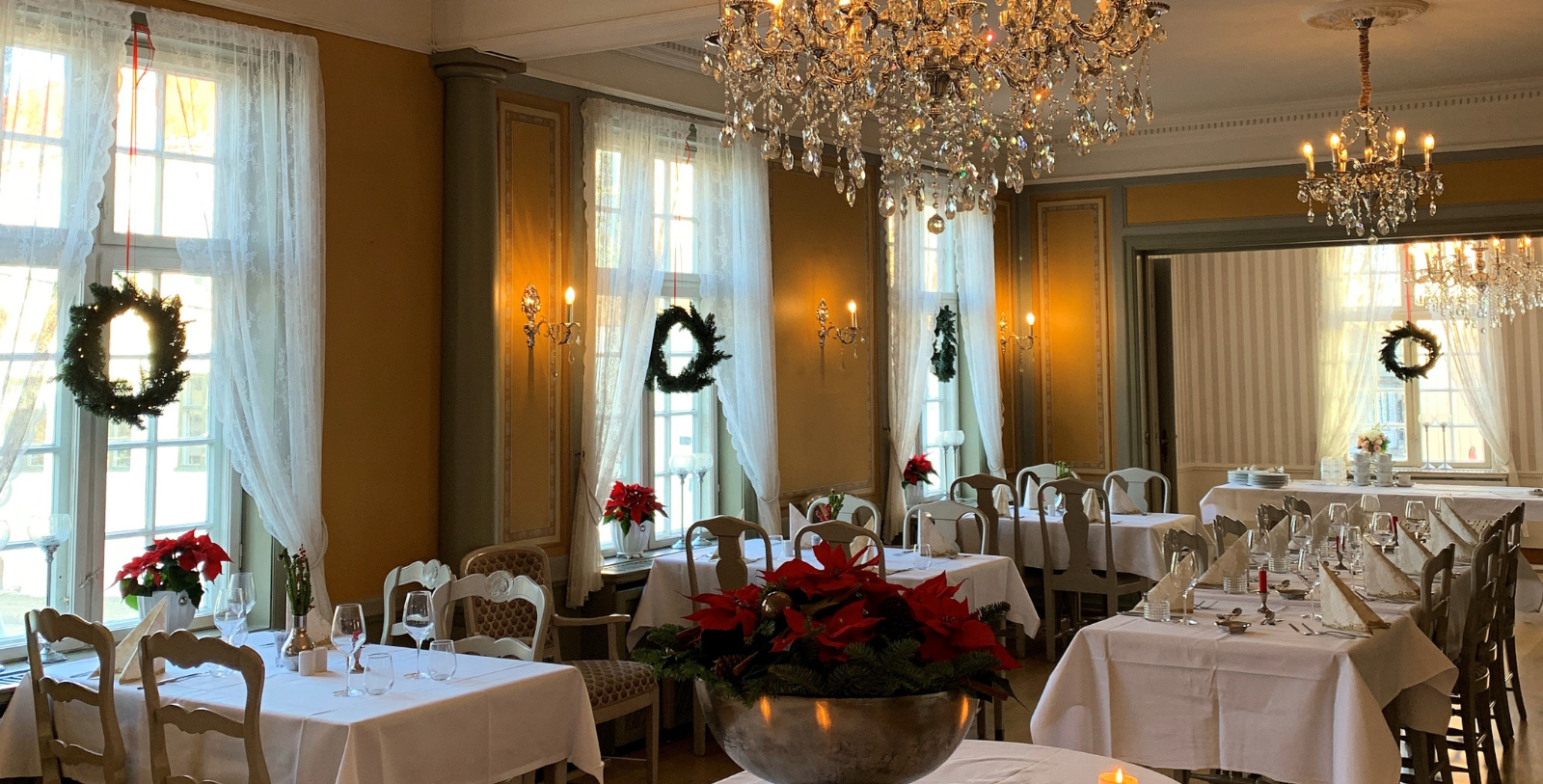 a room with tables and chairs and chandeliers