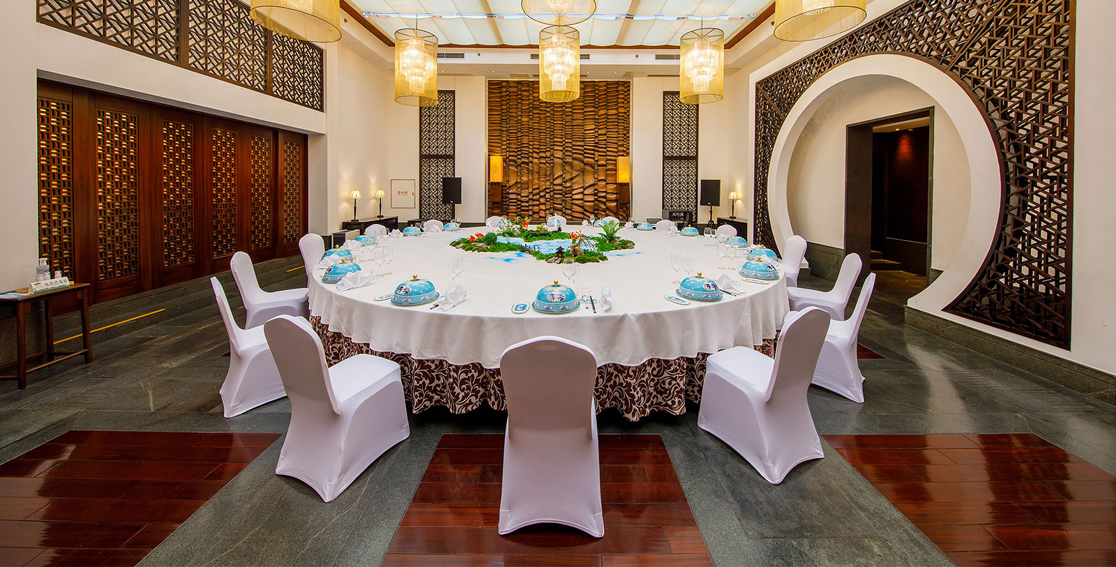 a round table with white chairs and a tablecloth