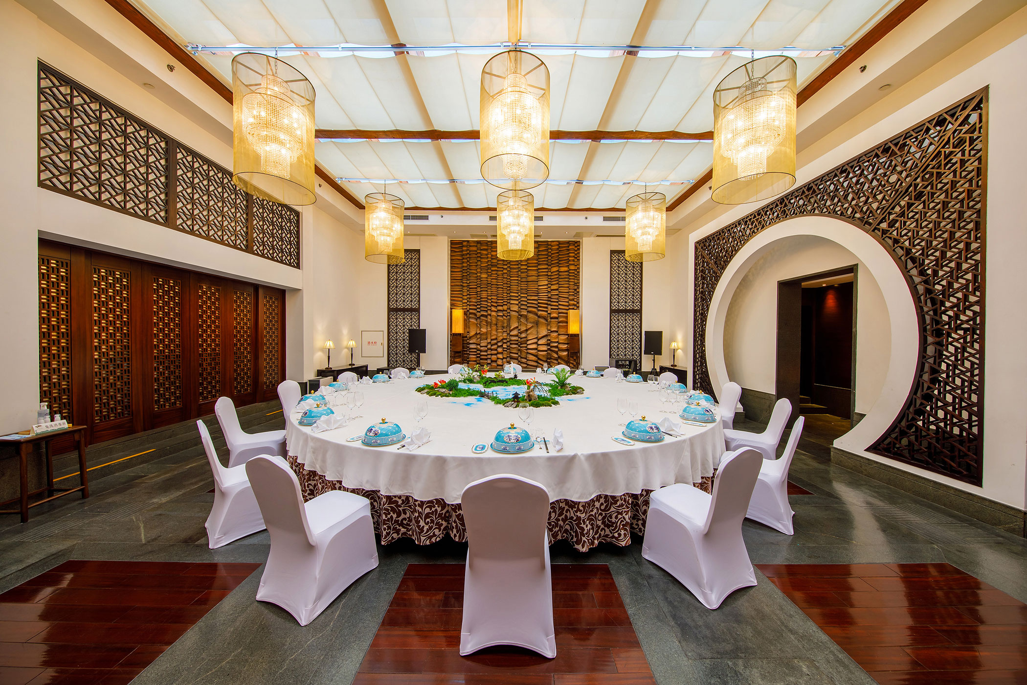 a large round table with white chairs and a table set up