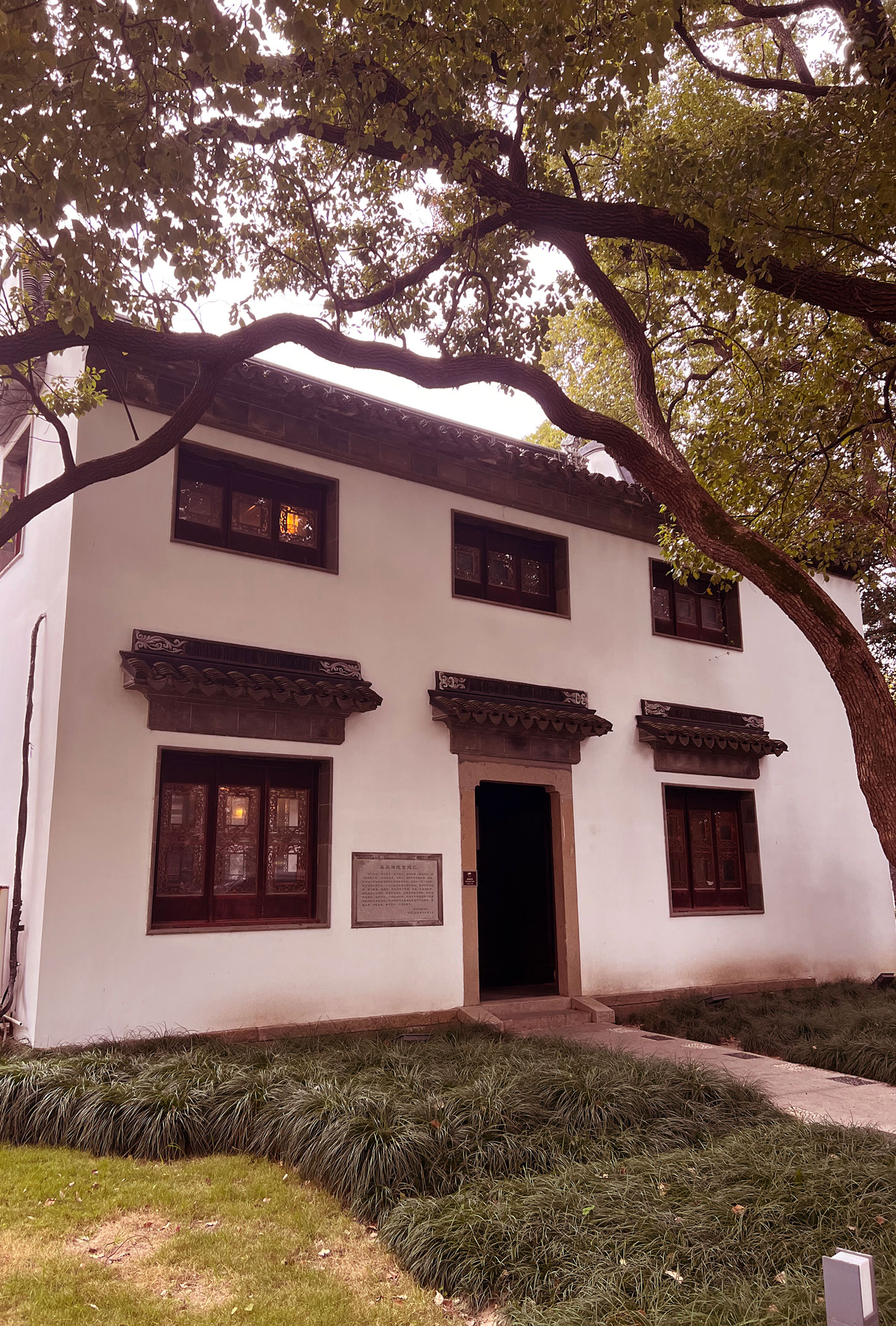 a white building with a tree in the background